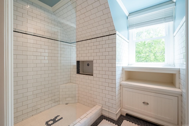 full bath with tile patterned floors, a tile shower, and ornamental molding