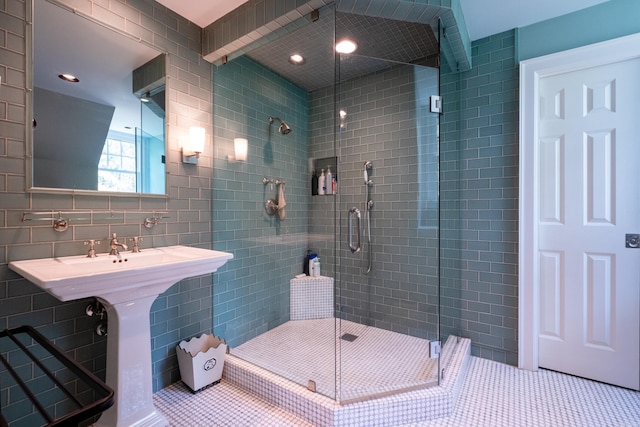 bathroom featuring tile patterned flooring, a stall shower, tile walls, and tasteful backsplash