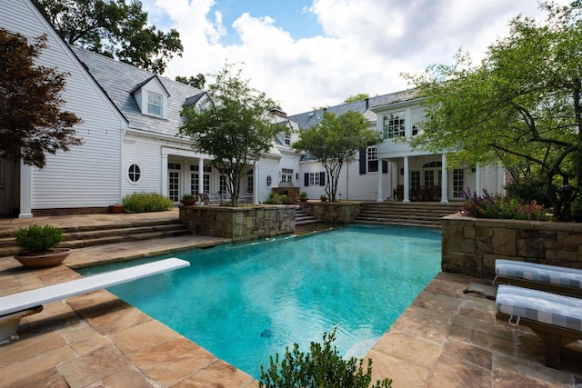 pool featuring a patio area, french doors, and a diving board