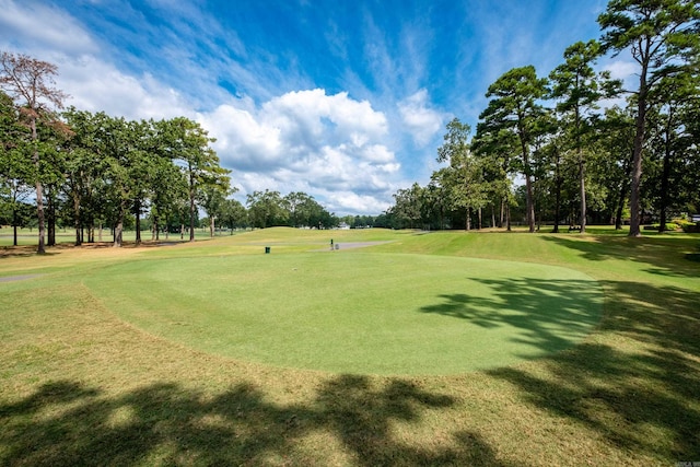 surrounding community featuring a yard and golf course view