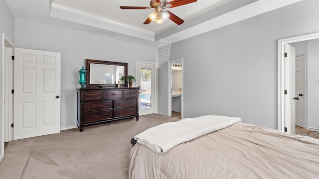 carpeted bedroom with ceiling fan, baseboards, a tray ceiling, and ornamental molding