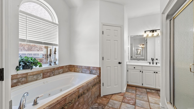 full bath featuring a tub with jets, a stall shower, vanity, and stone finish flooring