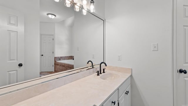 bathroom with tiled tub and vanity