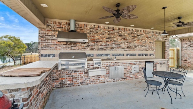 view of patio featuring grilling area, an outdoor kitchen, a ceiling fan, and fence