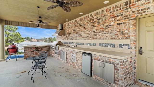 view of patio / terrace featuring area for grilling, an outdoor kitchen, ceiling fan, and a sink