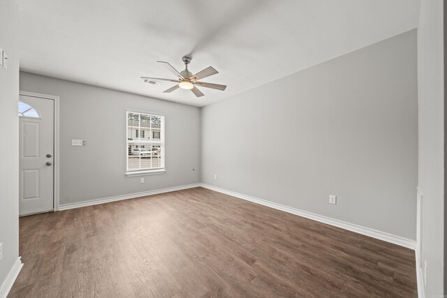 empty room featuring a ceiling fan, wood finished floors, visible vents, and baseboards