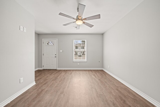 empty room featuring a ceiling fan, wood finished floors, and baseboards