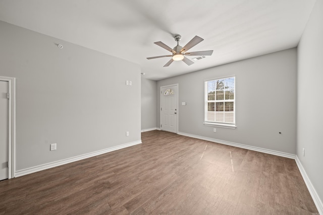 empty room featuring baseboards, wood finished floors, visible vents, and ceiling fan