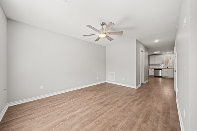 unfurnished living room with visible vents, baseboards, wood finished floors, and a ceiling fan