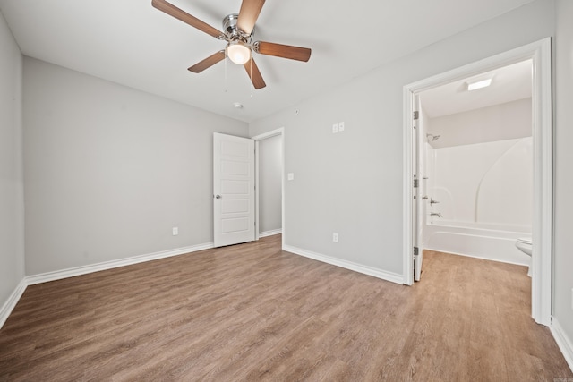 unfurnished bedroom with a ceiling fan, wood finished floors, and baseboards