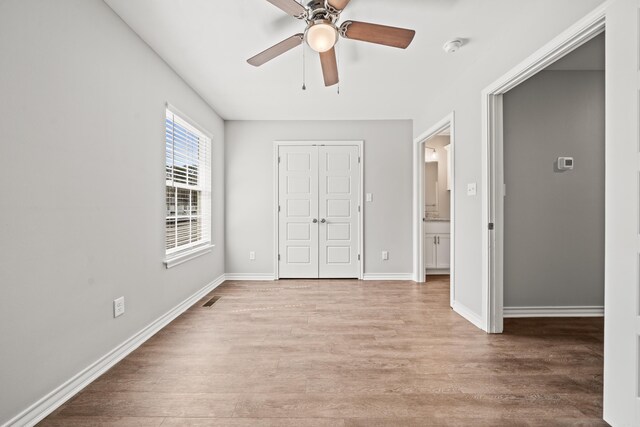 unfurnished bedroom featuring visible vents, a closet, light wood finished floors, baseboards, and ceiling fan