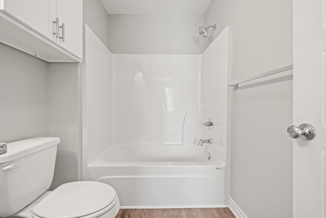 full bath featuring  shower combination, toilet, and wood finished floors