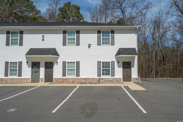 multi unit property with uncovered parking, brick siding, and roof with shingles