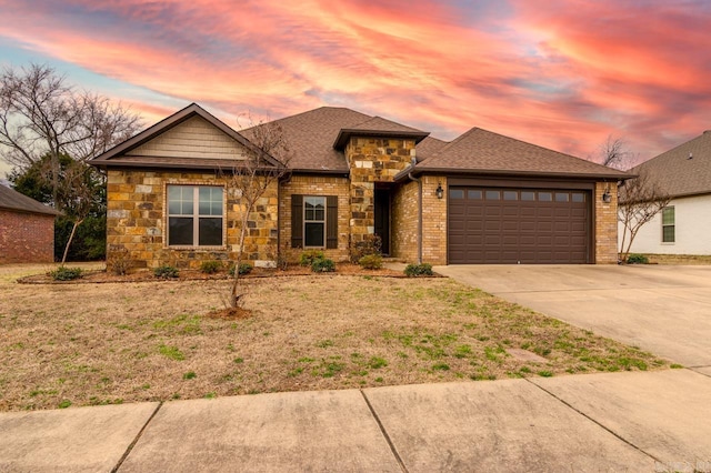 view of front of home featuring concrete driveway, an attached garage, stone siding, and a shingled roof