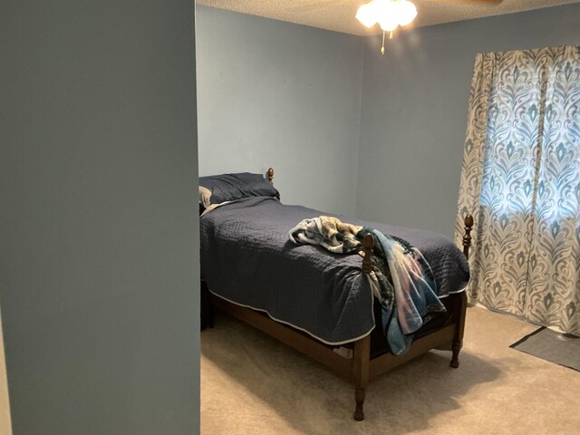 bedroom featuring light colored carpet and a textured ceiling