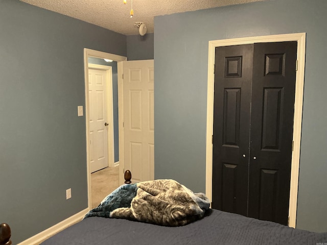 bedroom featuring a closet, baseboards, and a textured ceiling