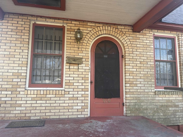 view of exterior entry with brick siding