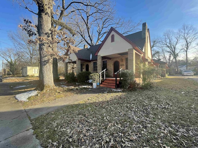 view of front facade featuring brick siding and a chimney