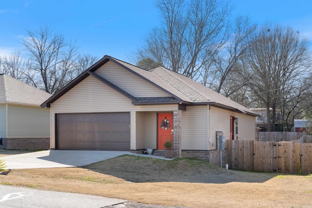 view of front of house with concrete driveway, an attached garage, fence, and roof with shingles