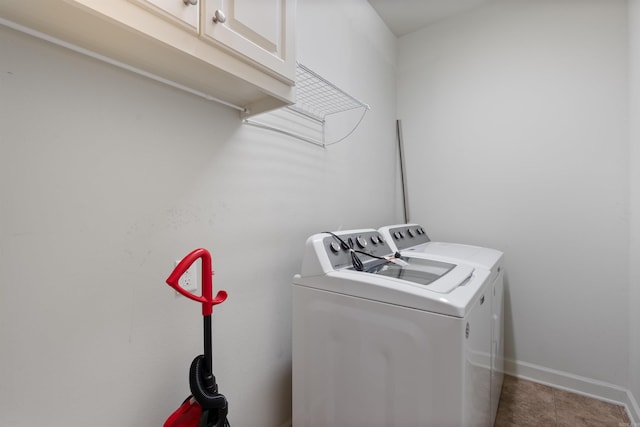 washroom with baseboards, cabinet space, and independent washer and dryer