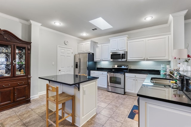 kitchen featuring visible vents, white cabinets, stainless steel appliances, and a sink