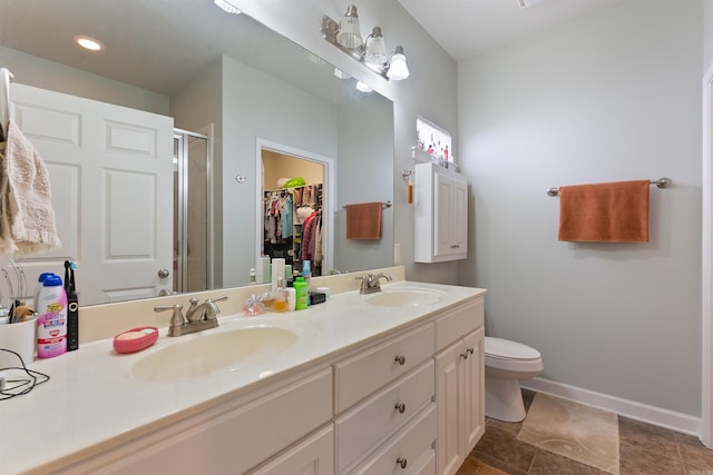 bathroom with a shower stall, toilet, double vanity, and a sink