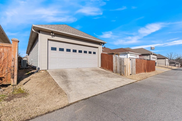 view of front of home featuring cooling unit, driveway, roof with shingles, and fence