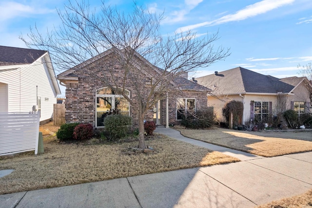 view of front of property featuring brick siding and a shingled roof