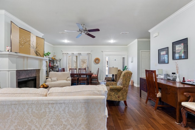 living area featuring dark wood finished floors, visible vents, a fireplace, and ornamental molding