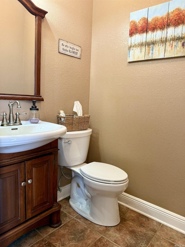 bathroom featuring vanity, toilet, and baseboards