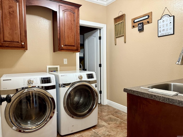 laundry room featuring baseboards, cabinet space, separate washer and dryer, a sink, and tile patterned flooring