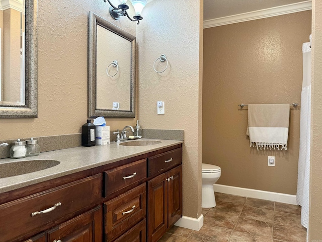 full bath with a sink, toilet, double vanity, and crown molding