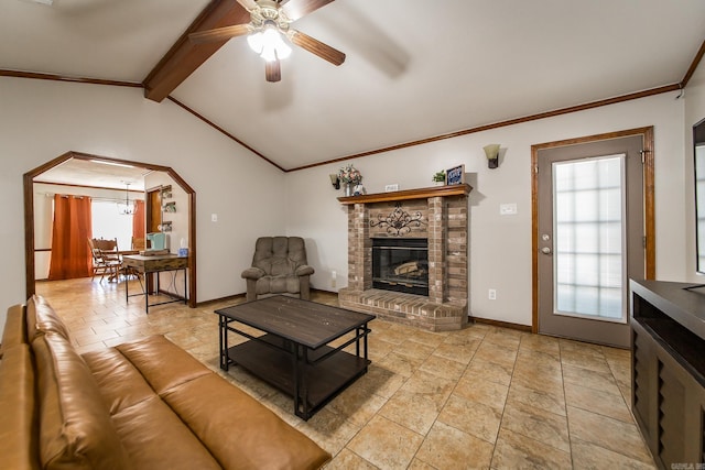 living area with a ceiling fan, lofted ceiling with beams, arched walkways, crown molding, and a brick fireplace