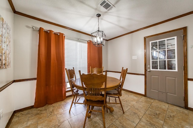 dining space featuring visible vents, baseboards, ornamental molding, an inviting chandelier, and a textured ceiling