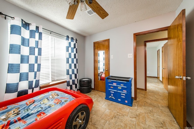 bedroom featuring ceiling fan, visible vents, and a textured ceiling