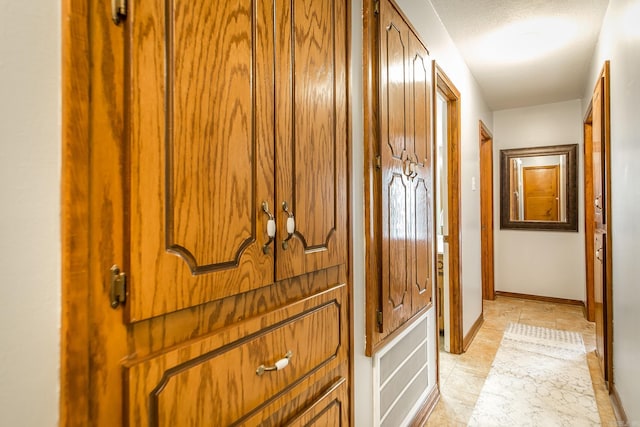 corridor with light tile patterned floors and baseboards