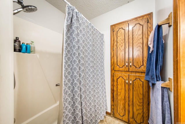 bathroom with curtained shower and a textured ceiling