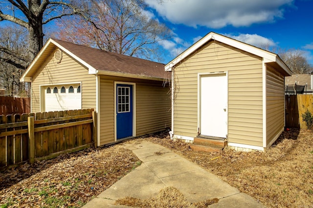 view of outbuilding with entry steps, an outdoor structure, and fence