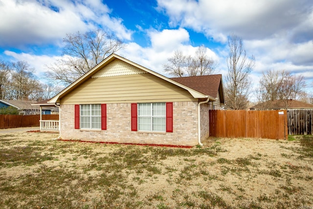 view of home's exterior with brick siding and fence