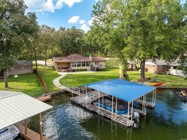 dock area featuring a water view, boat lift, and a lawn