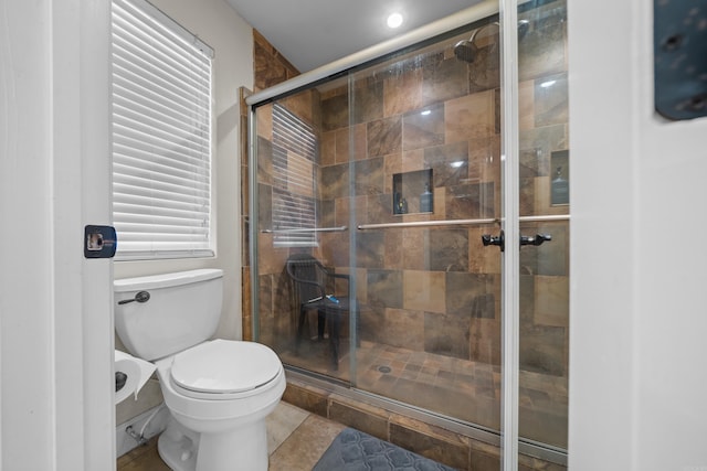 bathroom featuring a shower stall and toilet