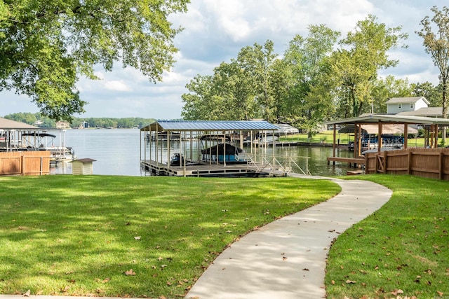 dock area with boat lift, a lawn, and a water view