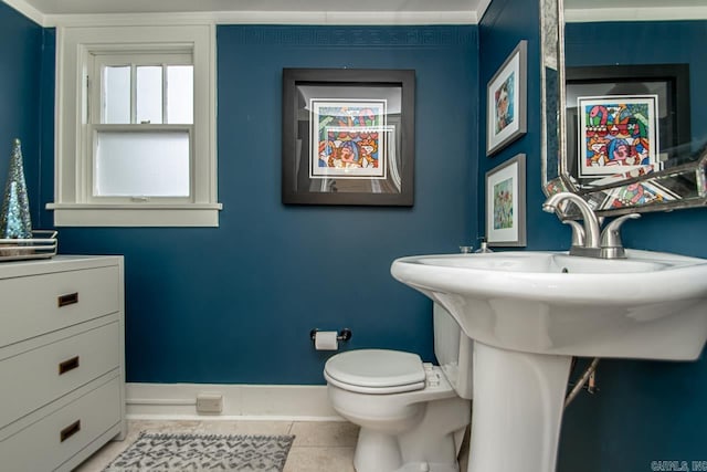 bathroom featuring baseboards, toilet, and tile patterned flooring