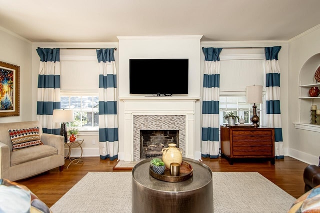 living area with a fireplace, wood finished floors, and ornamental molding