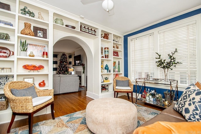 living area featuring arched walkways and wood finished floors