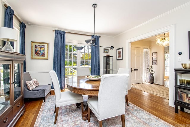 dining space featuring wood finished floors and crown molding