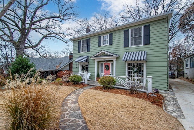 view of front of home with driveway and a chimney