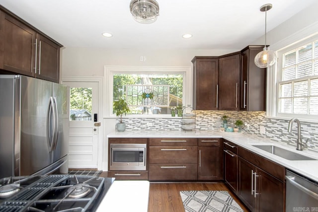 kitchen featuring a wealth of natural light, appliances with stainless steel finishes, tasteful backsplash, and a sink