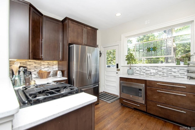 kitchen featuring backsplash, dark wood finished floors, recessed lighting, dark brown cabinetry, and appliances with stainless steel finishes