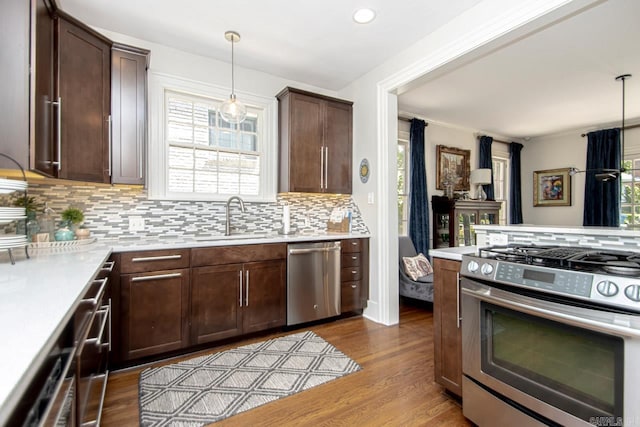 kitchen featuring light countertops, a wealth of natural light, appliances with stainless steel finishes, and a sink